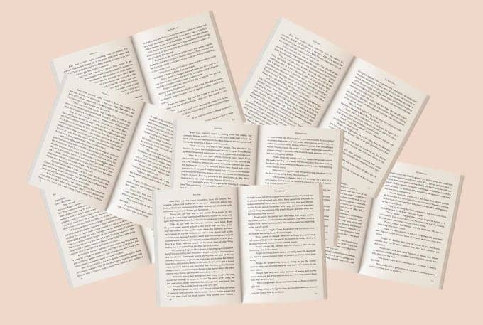 A stack of various books resting on a beige background, showcasing their colorful spines and diverse titles.